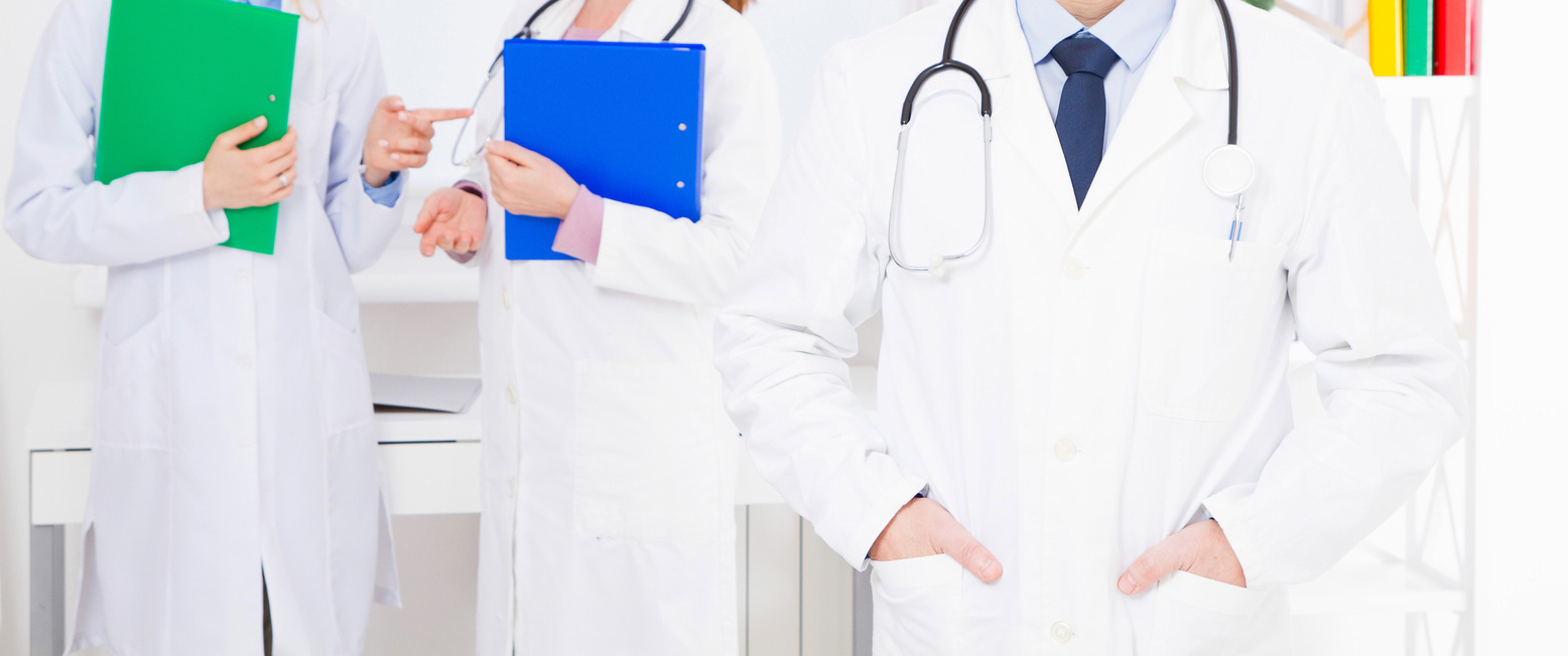 doctor posing in office with medical staff